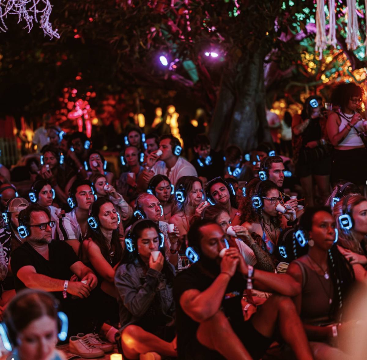 Crowd wearing glowing blue LED headphones facing the stage